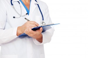 doctor with stethoscope writing report